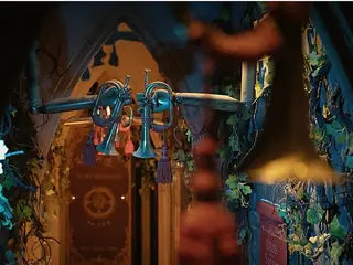 Brass trumpets and blue light around an ornate doorway in AURORA.