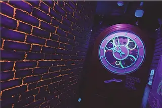An ornate clock glowing blue on a time-worn wall in AURORA.