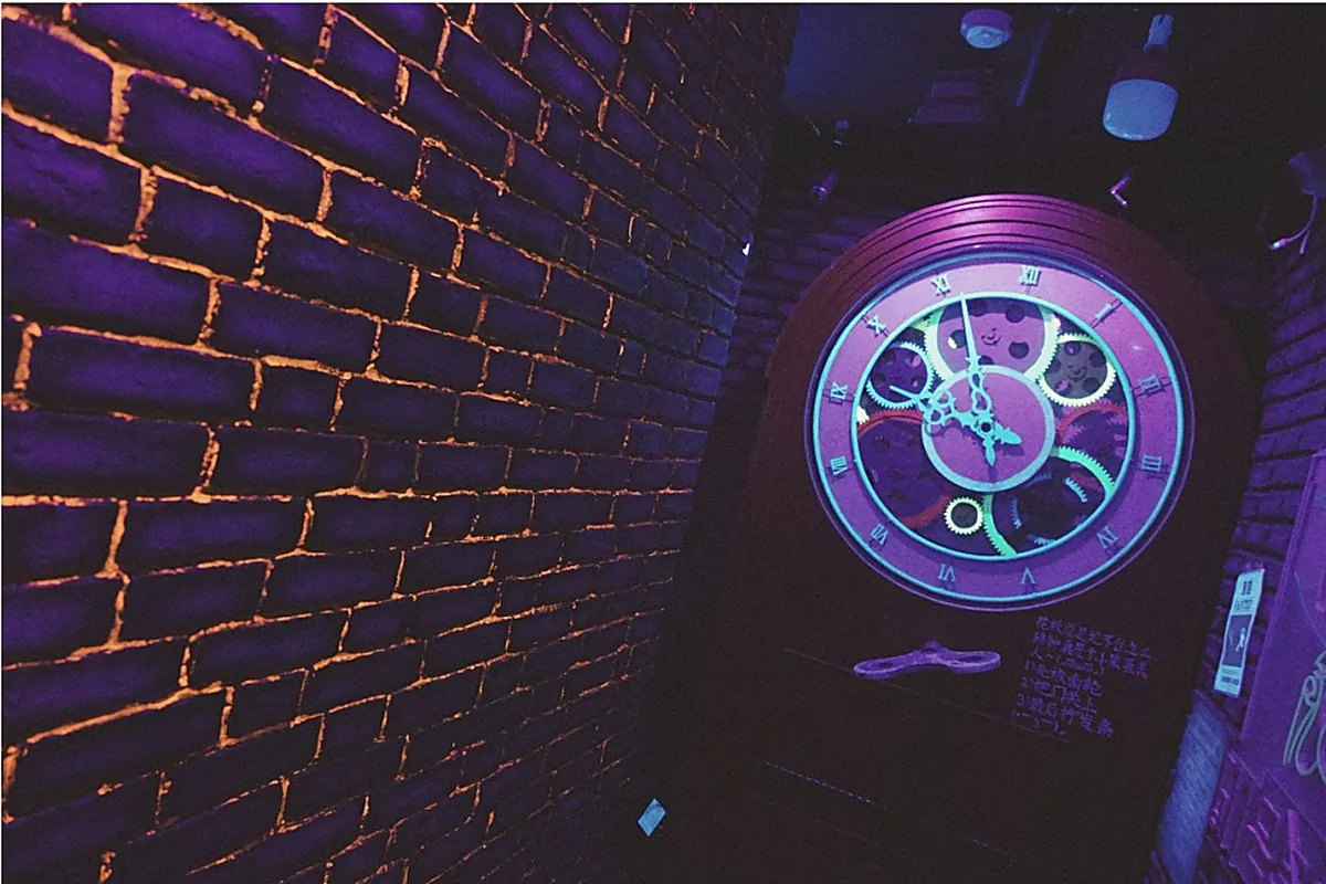 An ornate clock glowing blue on a time-worn wall in AURORA.