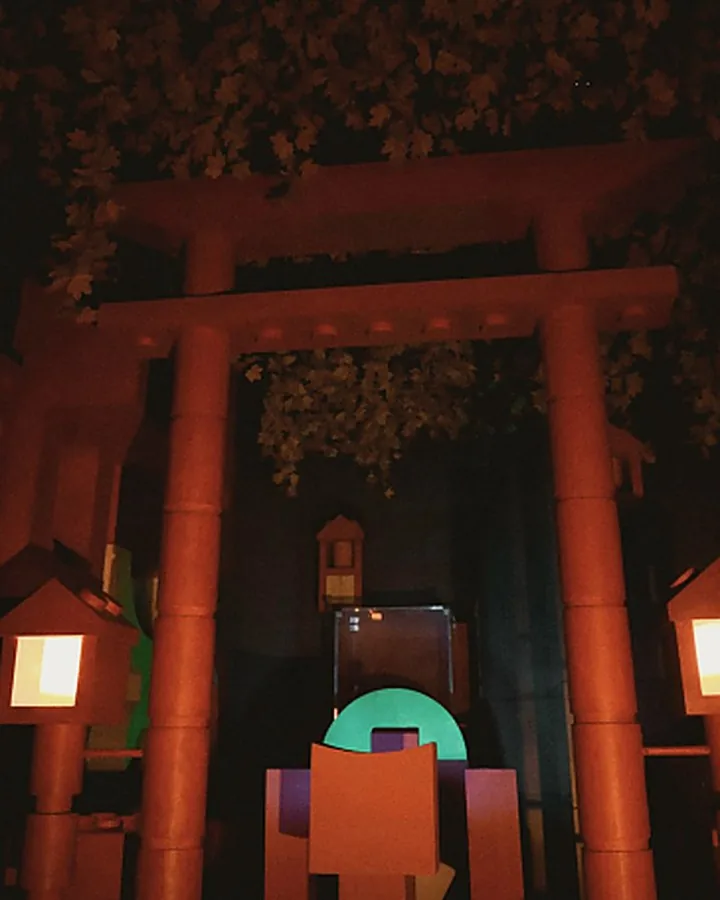 A dark wooden gateway with a green glow beyond — a scene from AURORA.